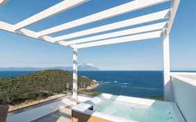 Atemberaubender Ausblick von der eigenen Terrasse mit beheizbarem Außenwhirlpool der Junior Suite mit Liegestühlen und Sitzecke